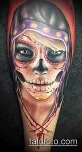 Фото тату женского лица в стиле Sugar Skull на предплечье. Яркие цвета, необычный головной убор, детальная прорисовка.