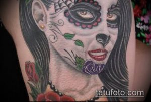 Фото тату женского лица в стиле Sugar Skull на плече. Черно-белая графика, цветочные элементы, детальная прорисовка.