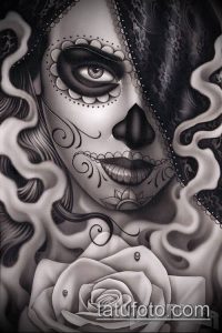 Фото тату: изящный женский череп с розой, выполненный в технике blackwork. Детализированный рисунок татуировки с акцентом на глаза и узоры.