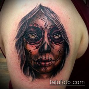 Фото татуировки в стиле Sugar Skull на плече. Изображение женского черепа с темным макияжем и загадочным взглядом.