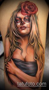 Фото татуировки в стиле Sugar Skull на плече. Изображение девушки с черепом, украшенной розой и ярким макияжем.