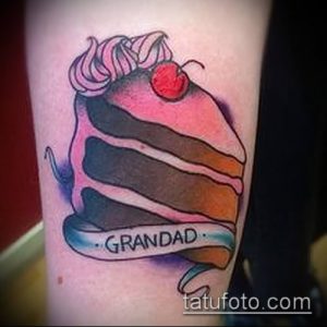 Фото тату на руке: кусок торта с вишней и надписью 'Grandad'. Простой и трогательный рисунок татуировки.