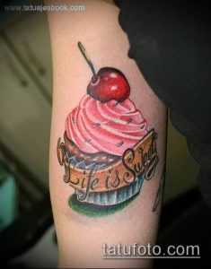 Фото тату капкейка с вишней и надписью 'Life is Sweet'. Красивый и позитивный рисунок татуировки, выполненный в ярких цветах.