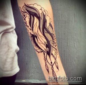 Фото тату: изящная татуировка в виде пера, выполненная в технике blackwork на предплечье, с тонкими линиями и геометрическими узорами.