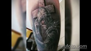 Фото тату на руке: воин в шлеме с мечом, в драматичной позе. Черно-серые тона, детализированная проработка, реалистичный стиль.