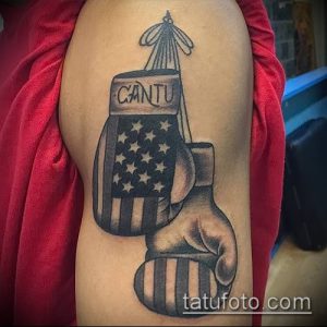 Фото тату: татуировка боксерских перчаток с американским флагом и надписью 'Cantu' на плече.