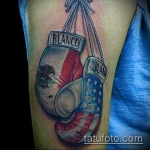 Фото тату: боксерские перчатки с мексиканским флагом и надписью 'Blanco' на предплечье, яркие цвета, реалистичный рисунок.