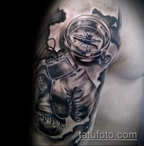 Черно-серое фото тату на груди мужчины с изображением компаса и боксерских перчаток, выполненное в реалистичном стиле с использованием теней и брызг.