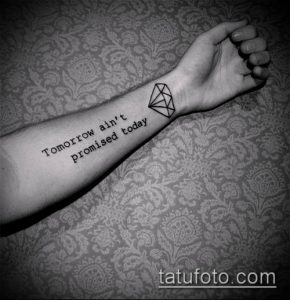 Фото тату: Черный бриллиант и надпись "Tomorrow ain't promised today" на предплечье. Стильная и вдохновляющая татуировка.