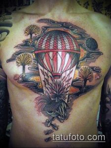 Фото тату: татуировка с воздушным шаром, из которого свисает череп, на груди. Черно-белый рисунок татуировки в готическом стиле.