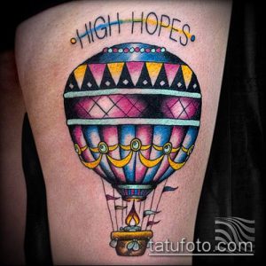 Фото тату: красочный воздушный шар на бедре с надписью 'High Hopes'. Традиционный стиль, яркие цвета, детальная проработка.