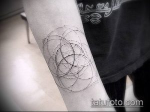 Фото тату: геометрический рисунок на предплечье. Черно-белая татуировка с использованием кругов, линий и точек.