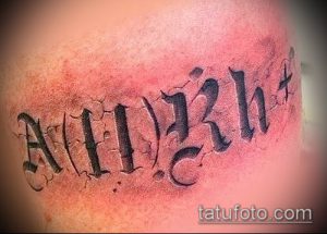 Фото татуировки с изображением группы крови A(II)Rh+, выполненной в стиле гранж на коже.
