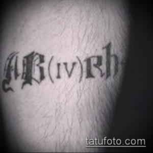 Фото тату с изображением группы крови AB(IV)Rh на руке, выполненное черными чернилами в минималистичном стиле.