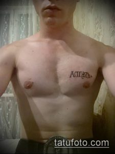 Фото татуировки с надписью на груди, выполненной в черном цвете. Мужественный дизайн и четкие линии.