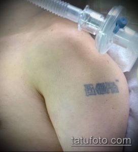 Фото татуировки с надписью на плече, выполненной в черном цвете. Четкий шрифт и аккуратное исполнение.