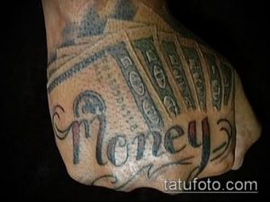 Фото татуировки на руке с изображением пачки денег и надписи 'Money'. Рисунок выполнен в простом стиле с использованием черно-серых тонов.