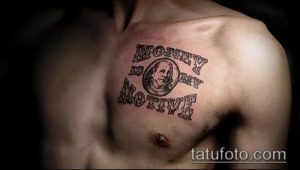 Фото тату на груди с надписью 'Money is my motive' и портретом Бенджамина Франклина. Черно-белый рисунок в стиле олдскул.