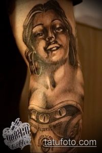 Фото тату, изображающее портрет красивой девушки на фоне денежных купюр. Рисунок выполнен в реалистичном стиле с использованием черно-серых оттенков.