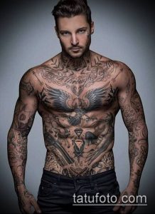 Фото тату в стиле blackwork на теле мужчины, изображающее орла, цветы и другие символы. Черно-белый рисунок татуировки, покрывающий большую часть тела.