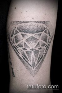 Фото тату бриллианта, выполненного в технике дотворк на руке. Изображение состоит из множества точек, создающих эффект градиента и блеска.