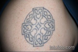 Фото тату: небольшая татуировка кельтского узла на плече, выполненная в черно-серых тонах с использованием тонких линий.