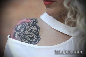 Фото тату: Черно-серая татуировка, имитирующая кружево на плече. Детализированный рисунок с плавными линиями и изящными узорами.