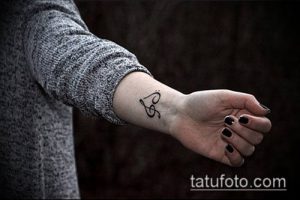 Фото тату скрипичного ключа на запястье. Черно-белый рисунок, выполненный тонкими линиями, для любителей музыки.