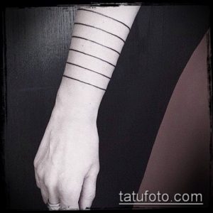 Фотография минималистичной татуировки на запястье, состоящей из нескольких параллельных черных линий. Простой и стильный рисунок татуировки.