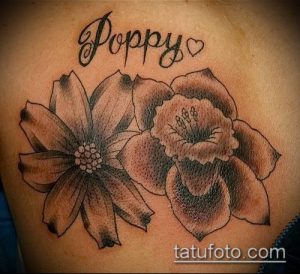 Фото татуировки с двумя нарциссами и надписью "Poppy" на груди. Черно-белый рисунок в стиле графика.