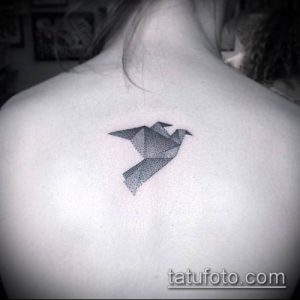 Фото тату: рисунок птицы оригами, выполненный точками (dotwork), расположен на верхней части спины. Оригинальный эскиз татуировки.