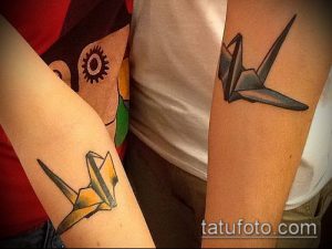 Две татуировки в стиле оригами на предплечьях. Изображены бумажные журавлики желтого и синего цветов.