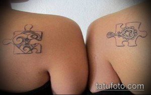 Фото парных татуировок в виде кусочков пазла на лопатках. Один кусочек пазла с узором, другой с сердцем. Символ любви и взаимодополнения.