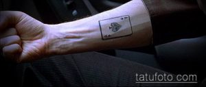 Фото минималистичной татуировки с изображением игральной карты на запястье. Простой и стильный рисунок татуировки, выполненный в черном цвете.