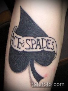Фото тату: черная татуировка с надписью 'Ace of Spades' на фоне пиковой масти. Простой дизайн, четкие линии, классический стиль.
