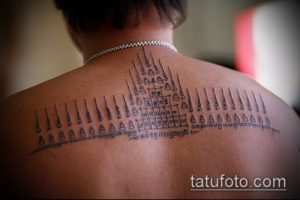 Фото тату: большая традиционная тайская татуировка сак янт, покрывающая спину мужчины. Видны геометрические фигуры и символы.