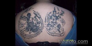 Фото тату: две симметричные сакральные татуировки на спине, выполненные черными чернилами в традиционном тайском стиле.