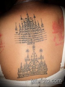 Фото тату: сложная татуировка сак янт на спине женщины, состоящая из геометрических фигур, символов и изображений.