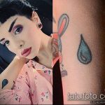 Фотография татуировки на руке девушки: маленькая капля слезы и рисунок зайчика. Чёрно-белое изображение.