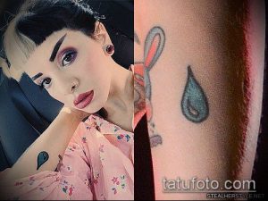 Фотография татуировки на руке девушки: маленькая капля слезы и рисунок зайчика. Чёрно-белое изображение.