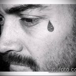 Фото тату черной капли слезы под глазом мужчины. Минималистичный рисунок татуировки.