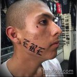 Фото тату надписи 'ERE' на щеке мужчины. Черно-белое изображение, демонстрирующее смелый и провокационный стиль.
