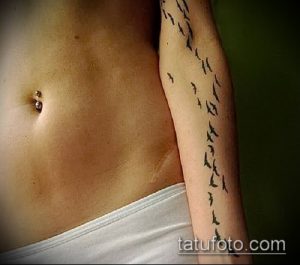 Фото тату: стая черных птиц, летящих вверх по предплечью, минималистичный рисунок татуировки, эскиз для вдохновения.