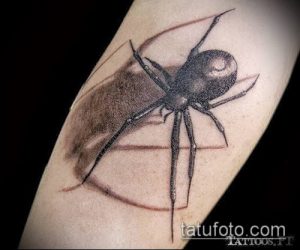 Фото тату паука на руке. Рисунок выполнен в технике blackwork, с использованием плотных черных заливок и геометрических форм. Стильный эскиз тату для любителей графики.