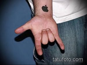 Фото минималистичной татуировки логотипа Apple на запястье. Черный рисунок татуировки.