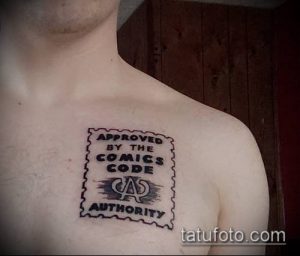 Фото татуировки на плече в виде печати с надписью 'Approved by the Comics Code Authority'. Черно-белый рисунок, символизирующий любовь к комиксам и ностальгию.