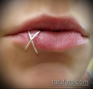 Фото пирсинга губы (Labret) с серебряным украшением в форме креста. Подчеркивает дерзкий и неординарный стиль.