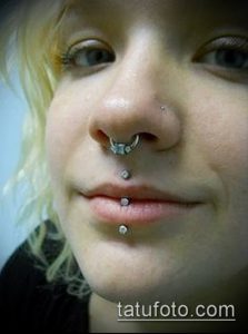 Фото пирсинга лица: прокол носа (septum) и несколько проколов губ (labret, monroe). Черно-белое изображение, акцент на симметрии.