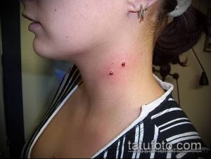 Фото пирсинга шеи с двумя небольшими украшениями. Изображение демонстрирует смелый и современный стиль пирсинга.