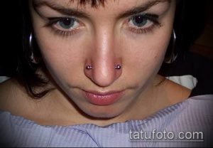 Фотография девушки с двойным пирсингом носа, украшенным фиолетовыми камнями. Видны большие глаза и светлые волосы.